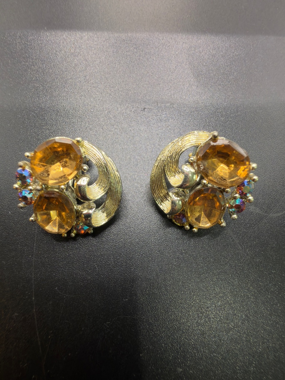 Vintage Lisner clip-on earrings gold-tone swirl Amber Aurora Borealis stones.